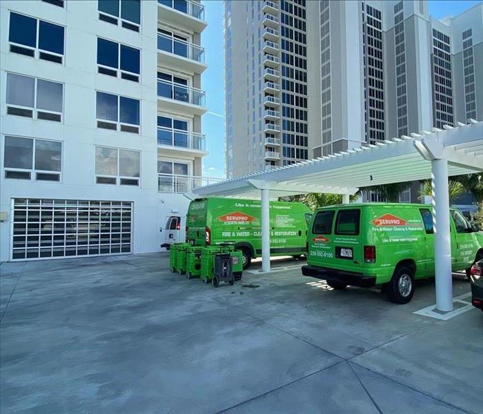 Two green SERVPRO vans parked outside.