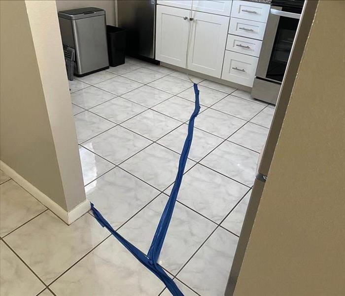 Room with white tile and a blue line of table running through it.